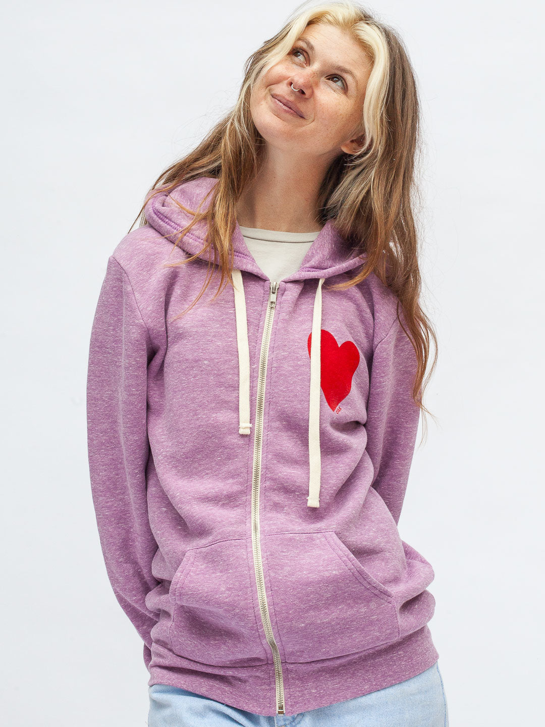 Person wearing a purple hoodie with a red heart on a light gray background