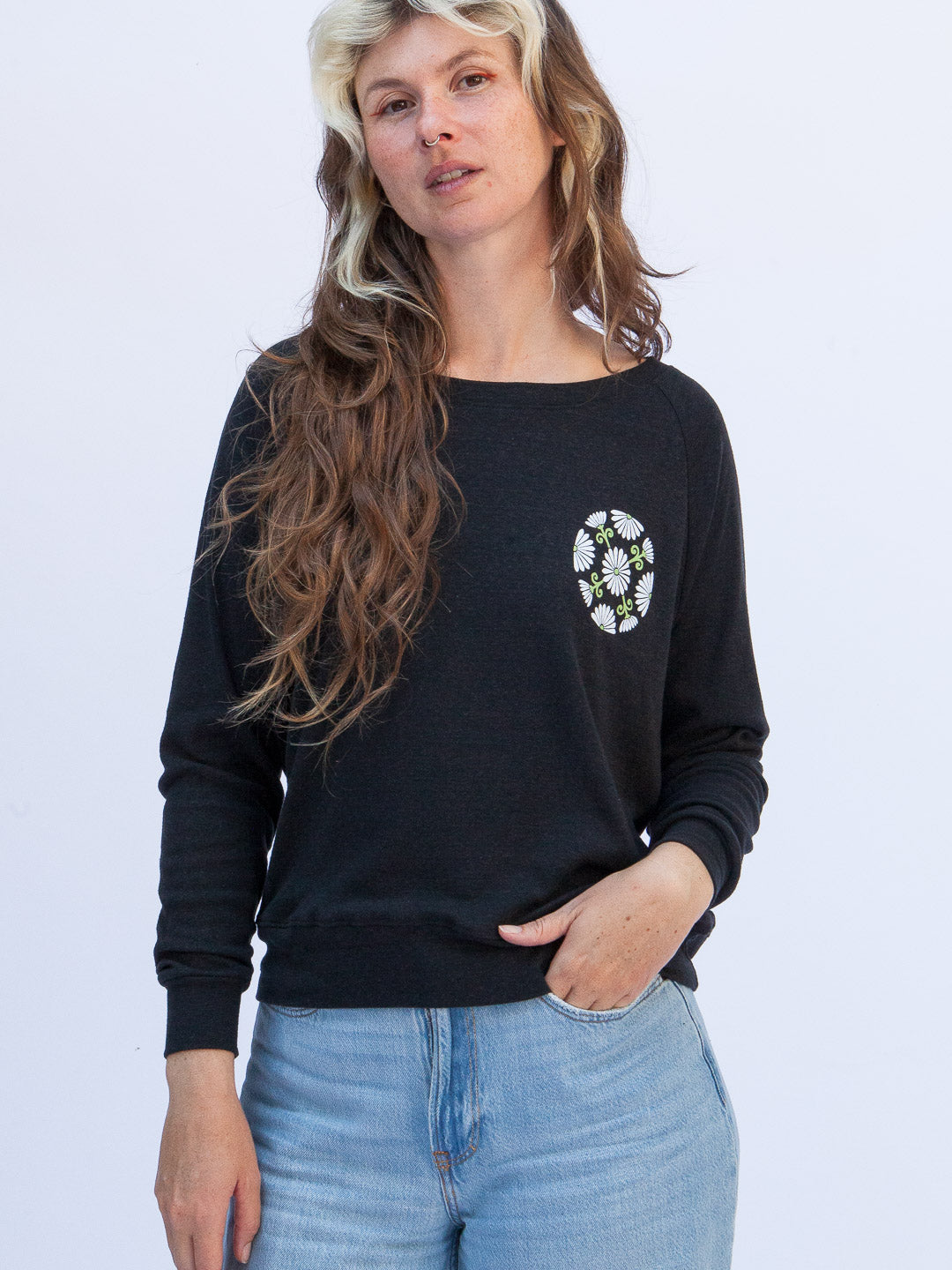 Woman wearing a black sweatshirt with a floral design on a white background