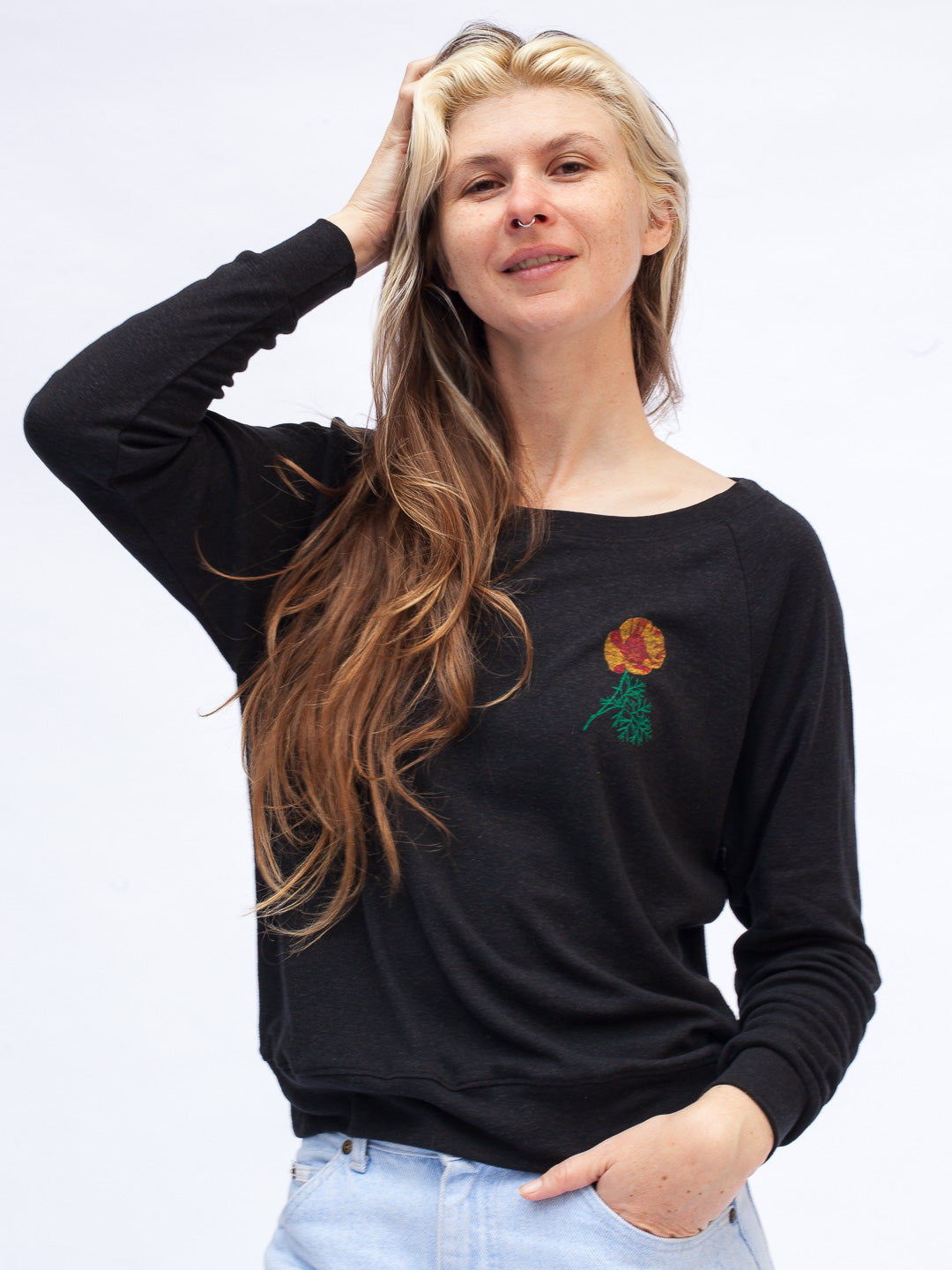 Woman wearing a black long-sleeve shirt with a colorful flower design on a white background