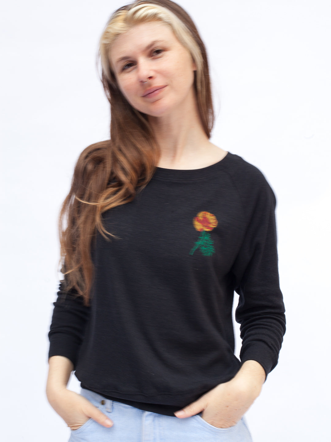 Woman wearing a black sweater with a colorful rose design on a white background