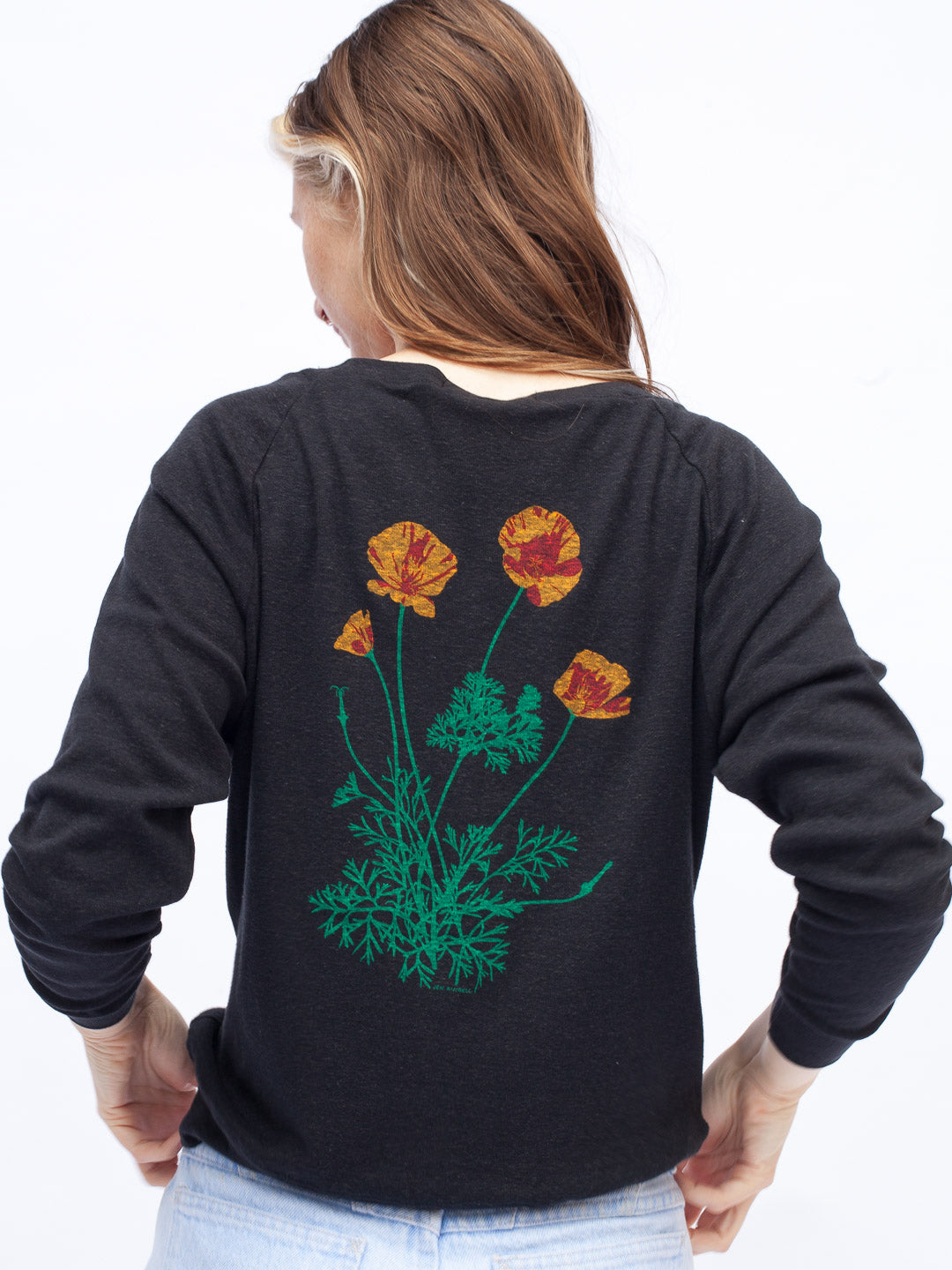 Woman wearing a black long-sleeve shirt with a colorful flower design on a white background