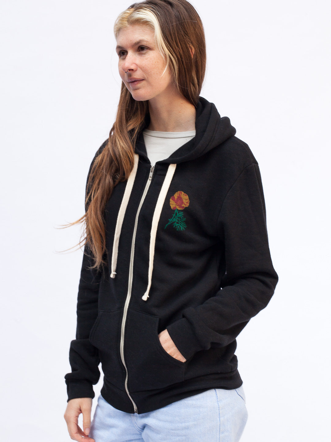 Woman wearing a black hoodie with a colorful logo on a white background